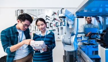 Asian Engineers Maintenance Robot Arm at Lab. they are in a High Tech Research Laboratory with Modern Equipment. Professional Japanese Development Engineer Testing an Artificial Intelligent.